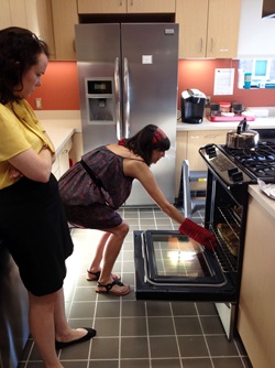 Women taking pan out of oven at Transplant House - guest chef program